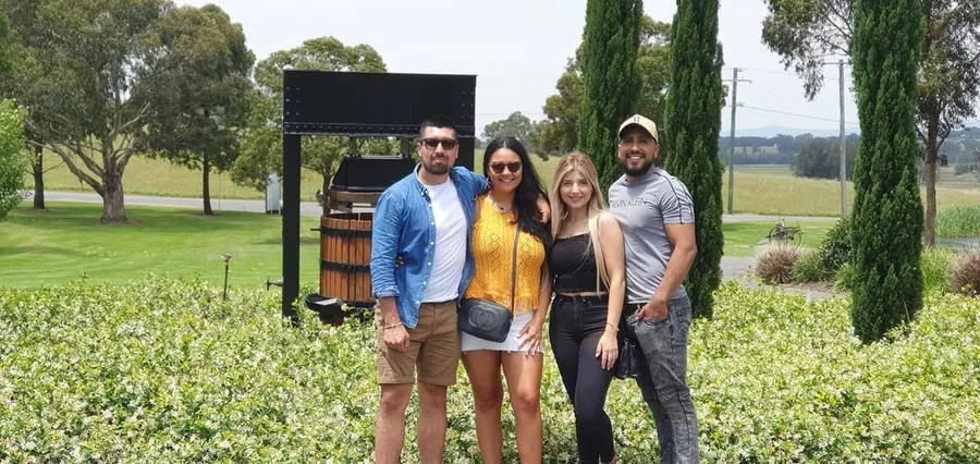 Guests beside the old wooden wine press in the Ben Ean gardens