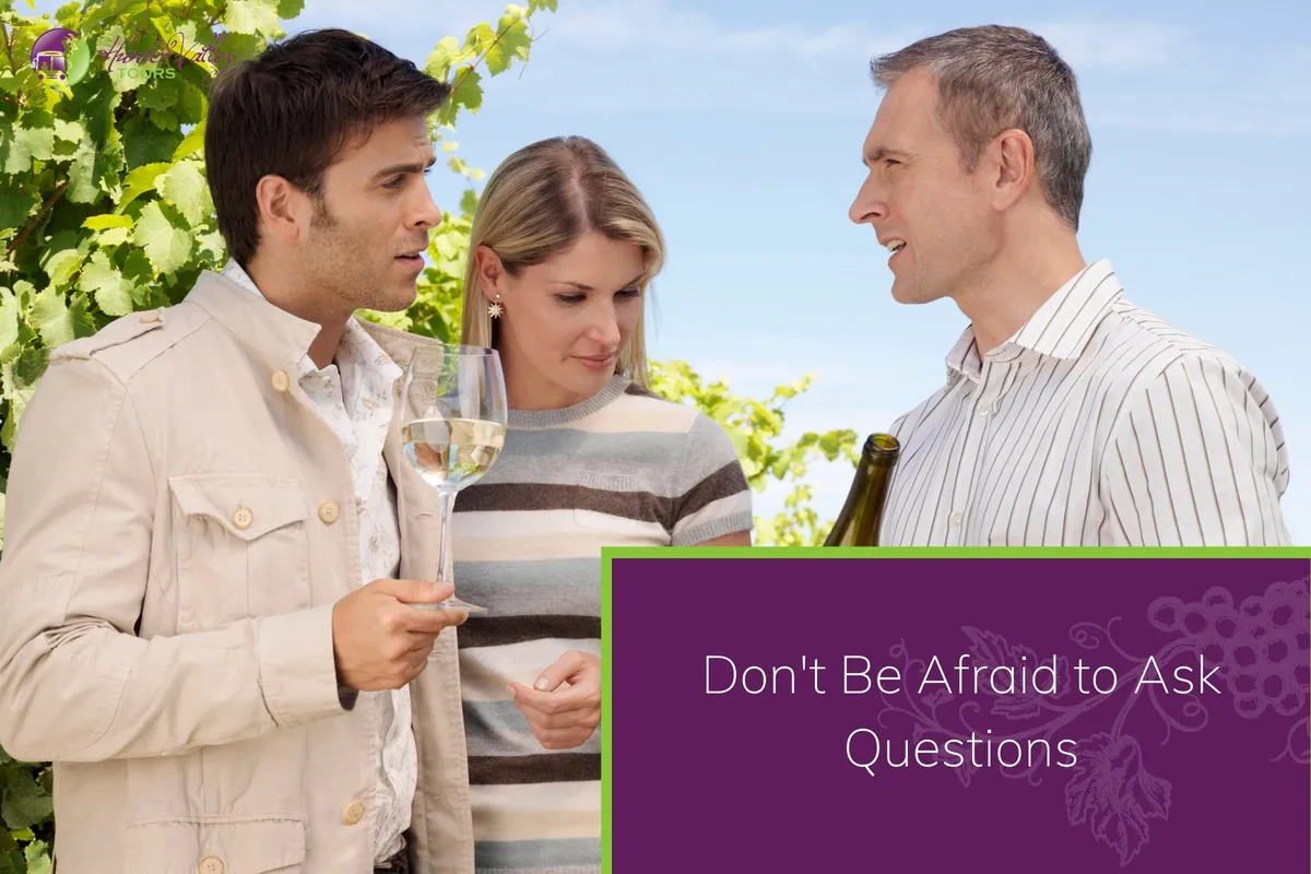 A couple listens to a wine expert explaining the details of a wine bottle in a vineyard.