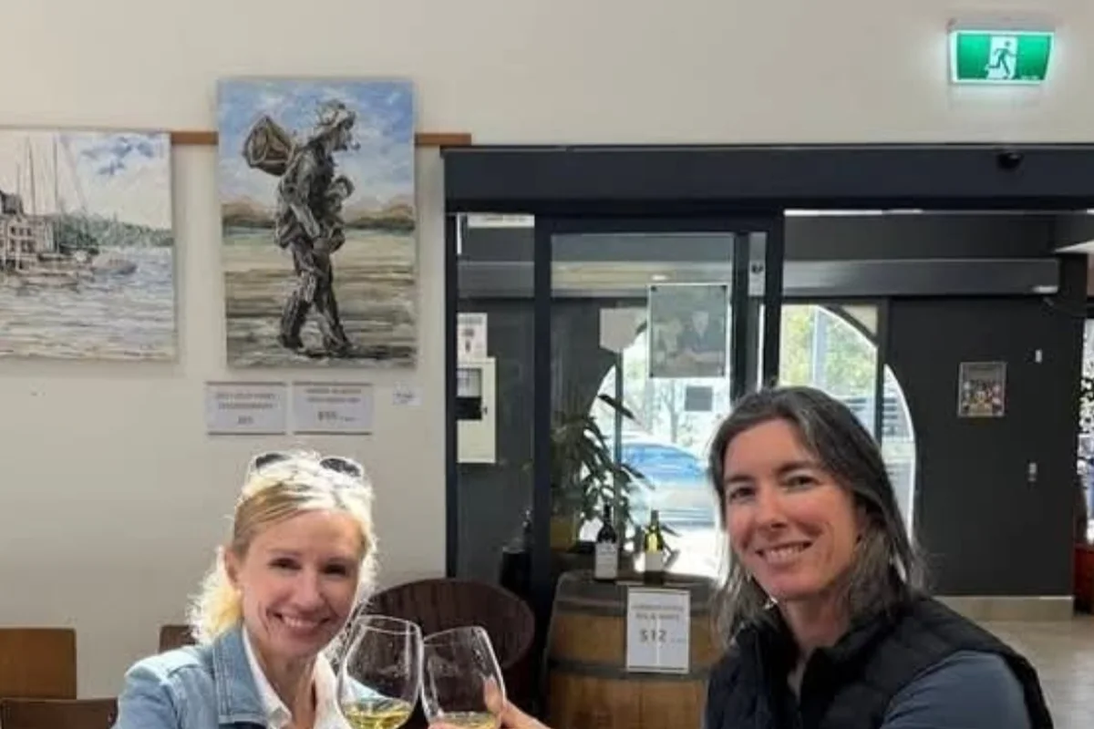 Two guests raising their glasses over a table of cheese and nibbles at a Hunter Valley tasting