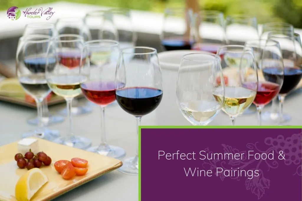 Elegant wine pairing setup with multiple glasses of red, white, and rosé wines, accompanied by cheese, grapes, and cherry tomatoes on an outdoor table.