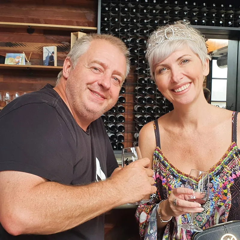 A birthday couple celebrates with wine, the guest of honour in her 50 tiara