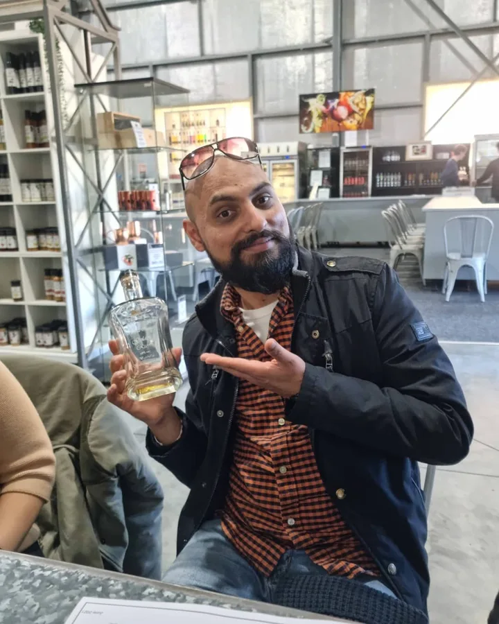 A tasting host presents a bottle at a Hunter Valley distillery