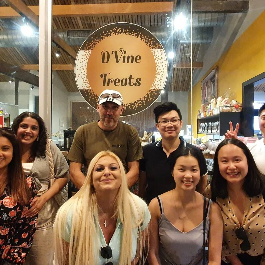 A tour group grins outside the D'Vine Treats chocolate shop