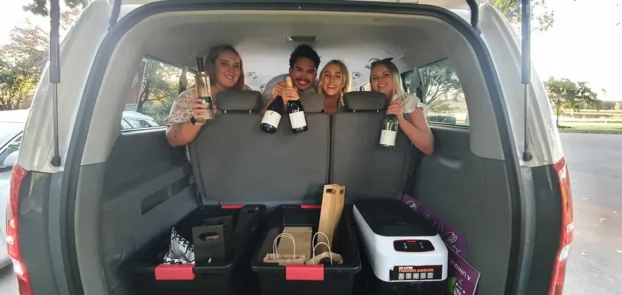 Guests in the back of the bus holding their wine hauls