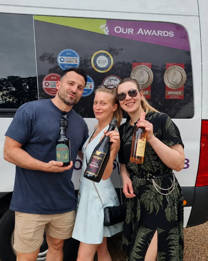 Guests holding bottles of wine on a Hunter Valley wine tour