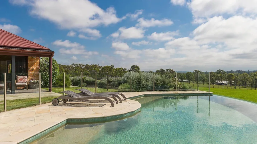 An infinity pool and lounges looking over Hunter Valley countryside